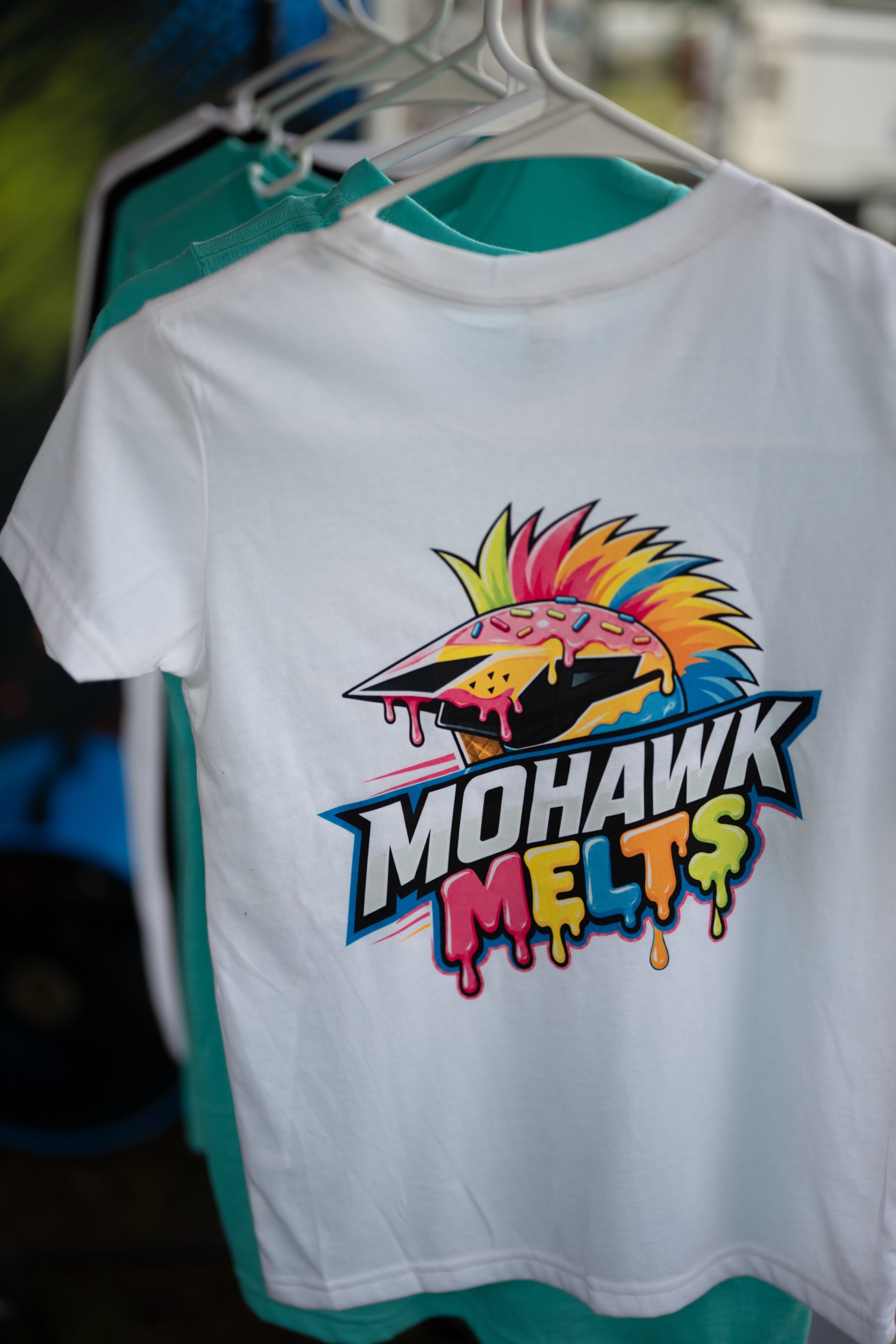 Mohawk Melts logo tee hanging at the merch rack